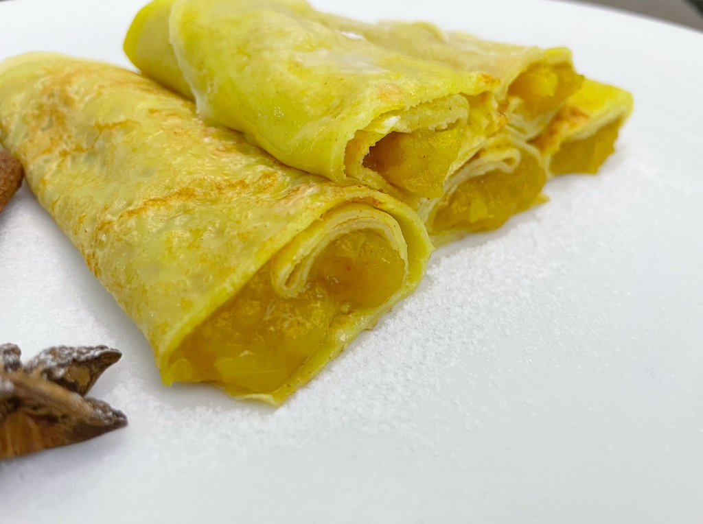 crepes with apple and walnut filling rolled on the serving plate