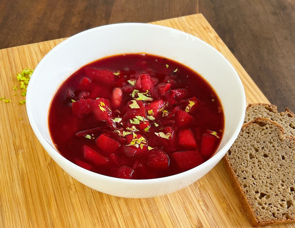 Ukrainian borscht in a serving bowl on the table with slices of rye bread