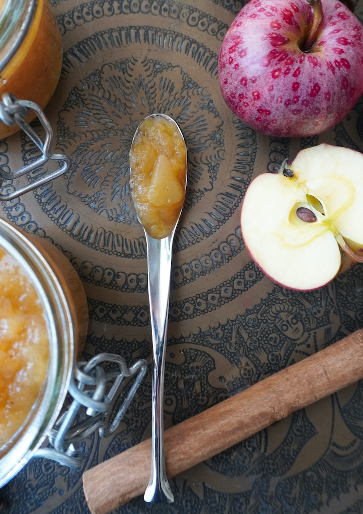 apple pie jam in a spoon apples and cinnamon stick arranged on brass Indian style platter flat lay