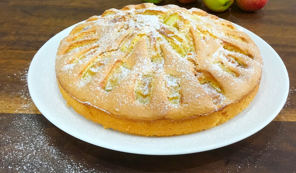 whole apple sponge cake on a serving plate