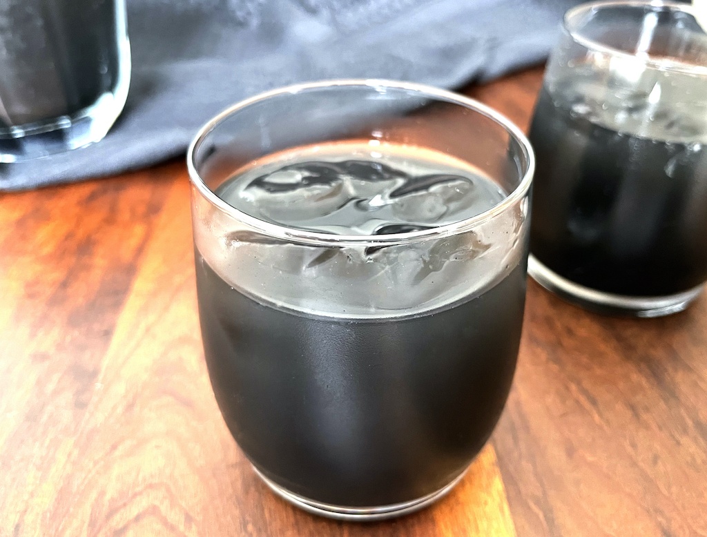 black halloween lemonade in a serving glass on the table