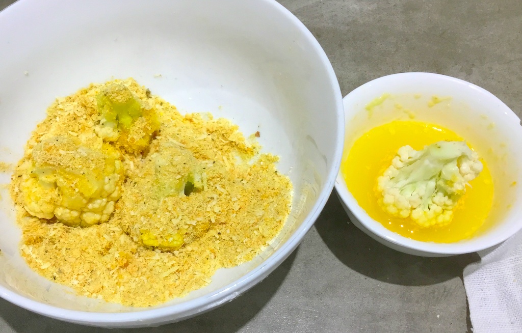 cauliflower chunks in two bowls - with melted butter and breadcrumbs