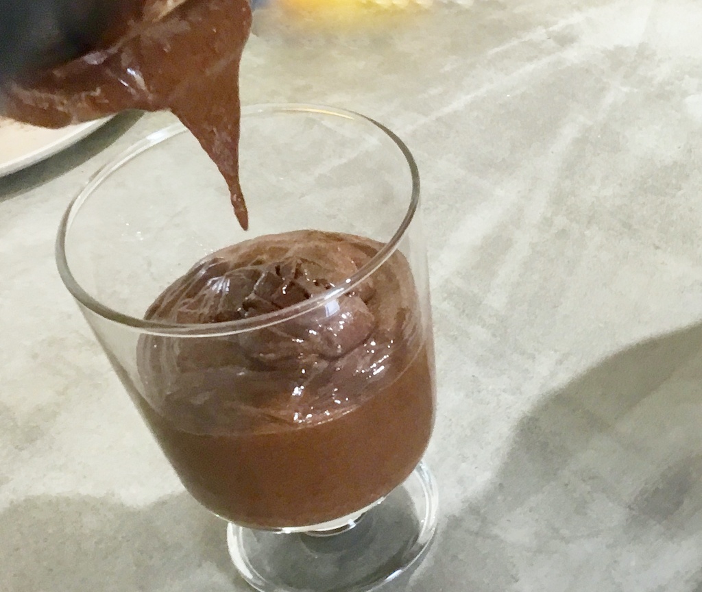 chocolate mousse being poured into the glass