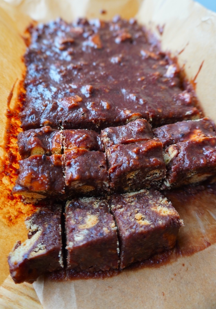 chocolate tiffin bar in baking parchment with three rows cut into cubes