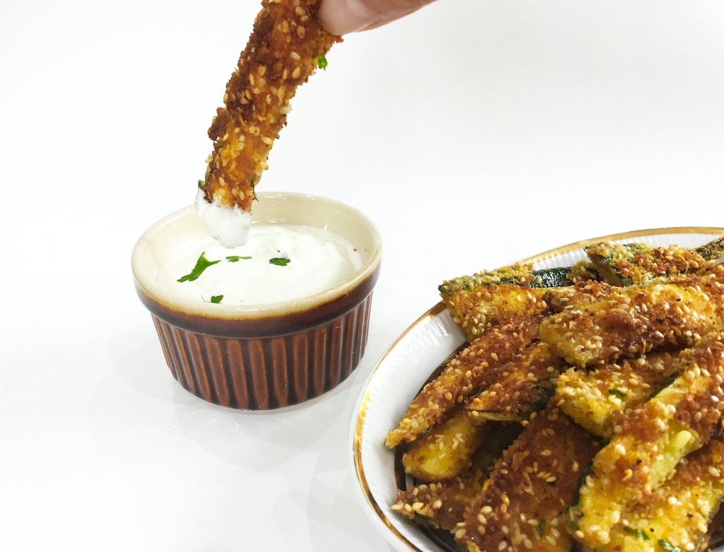 crispy courgette chips on the plate with one in the dip
