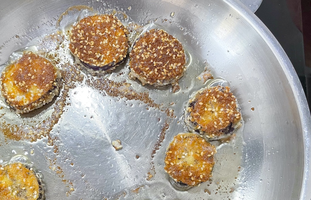 crispy fried aubergine in a frying pan