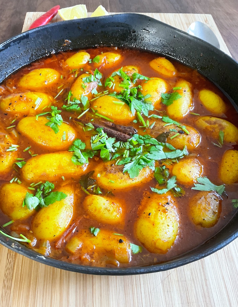 dum aloo or dum alu in a cast iron skillet on the table - a close up