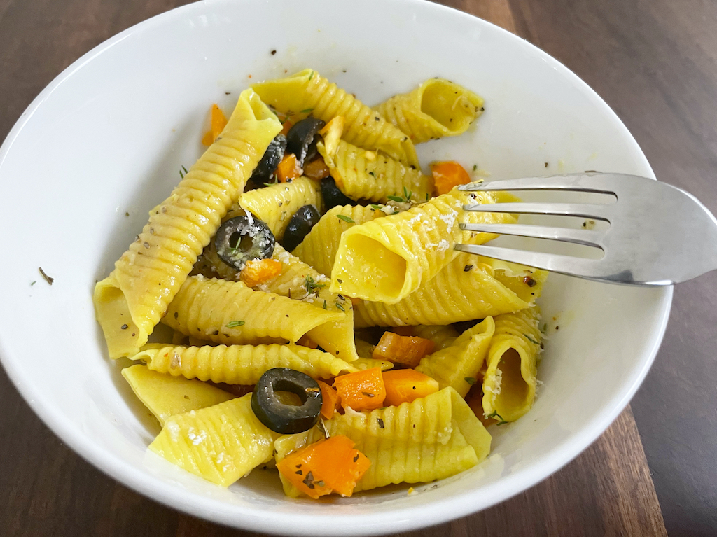 garganelli pasta in pasta salad in white bowl with a fork