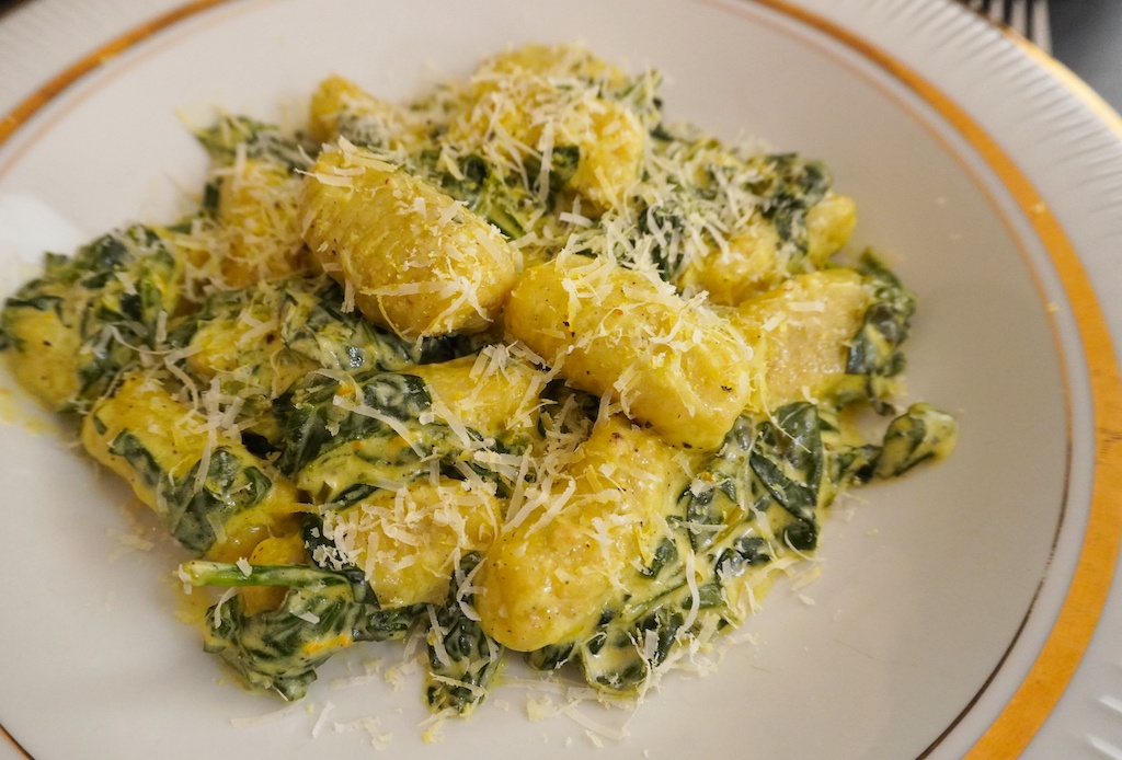 gnocchi with spinach and mascarpone in serving plate close view