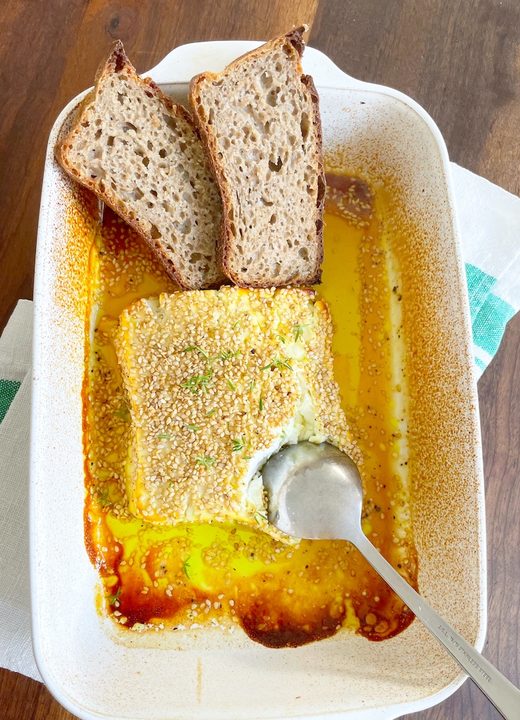 honey and lemon roasted feta in baking dish flat lay