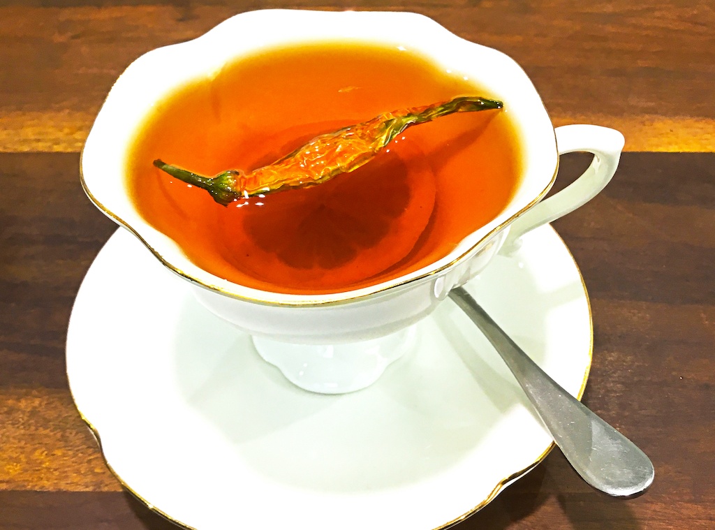Lemons Preserved in Honey in tea in a cup with a chilli pepper on top