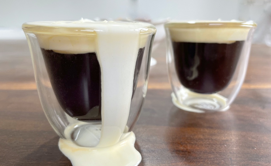 Irish coffee in two cups on the table seen from the front