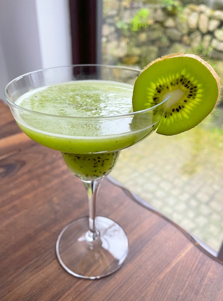 kiwi smash cocktail or mocktail in a glass on the table garnished with a kiwi slice