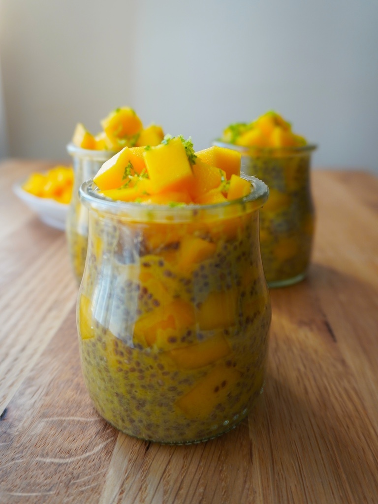 mango chia seeds pudding in glass containers on wooden worktop close view on one