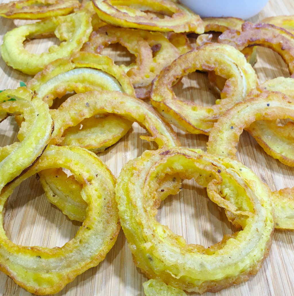 a close up on onion rings in beer batter