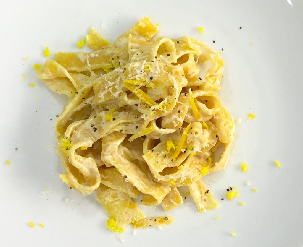 pappardelle pasta with lemon peel on the plate seen from the top