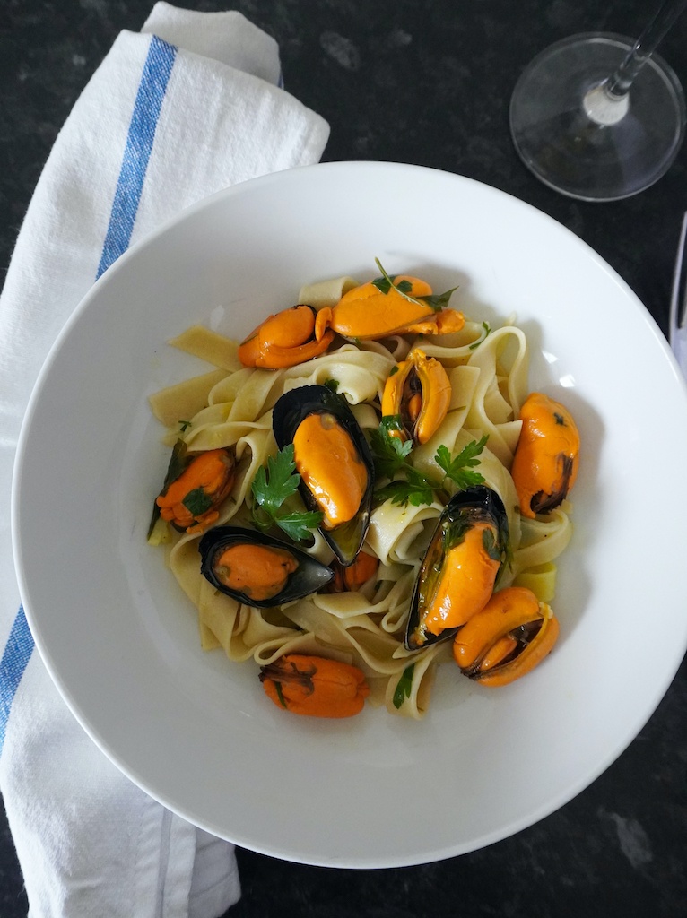 pasta with wine and garlic mussels in pasta bowl flat lay