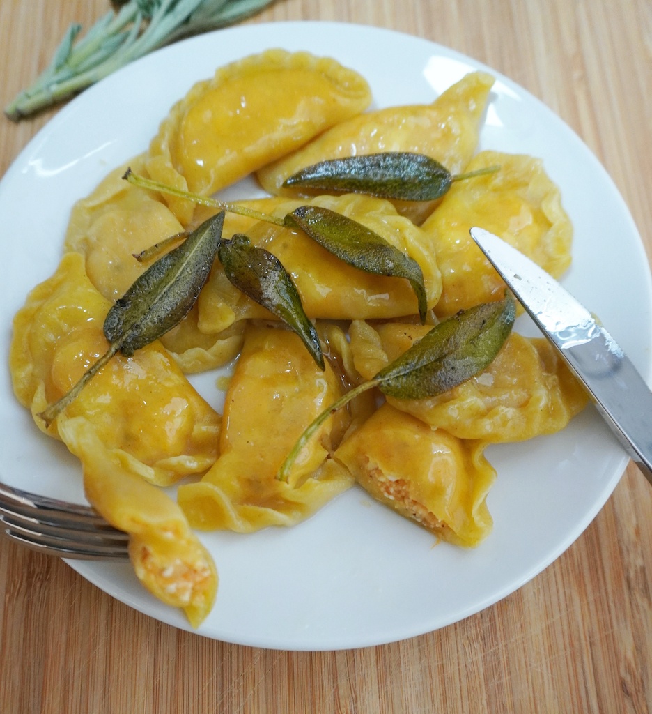 pierogi dumplings on the serving plate with one dumpling cut through