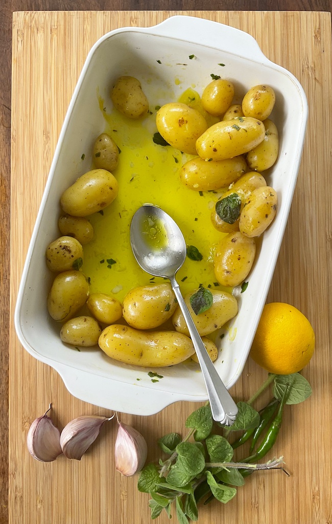 potatoes in salmoriglio sauce in a white dish flat lay