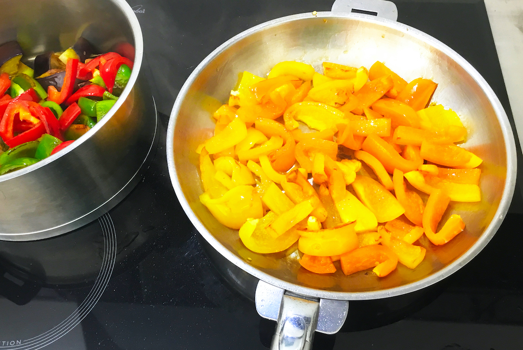 ratatuille - the french vegetable goulash in preparation frying the yellow and orange peppers