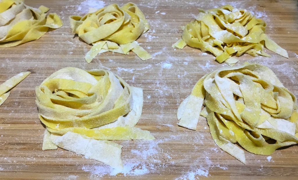 raw tagliatelle pasta on the chopping board