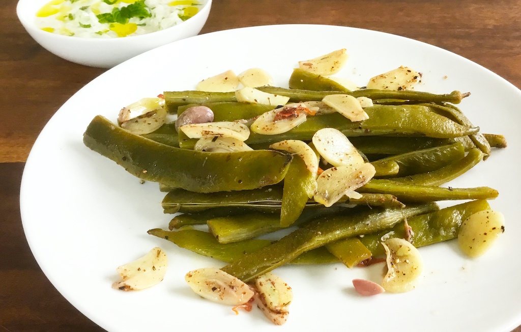 runner beans with tzatzyki on the plate - seen from the front