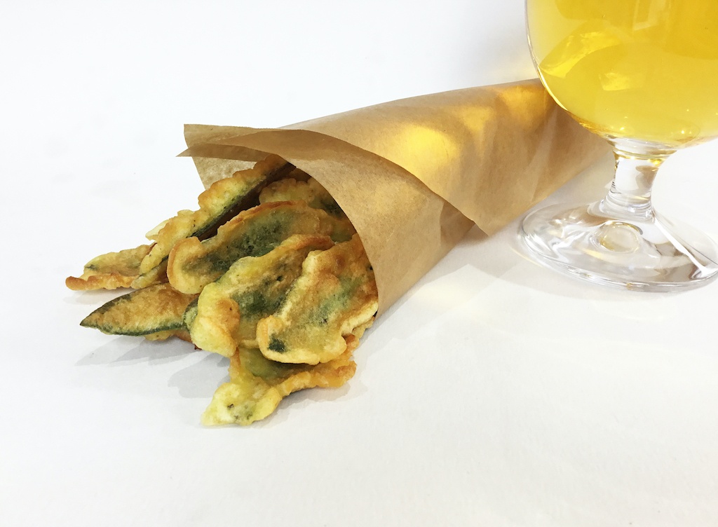 sage leaves in beer batter in a cone with a glass of beer