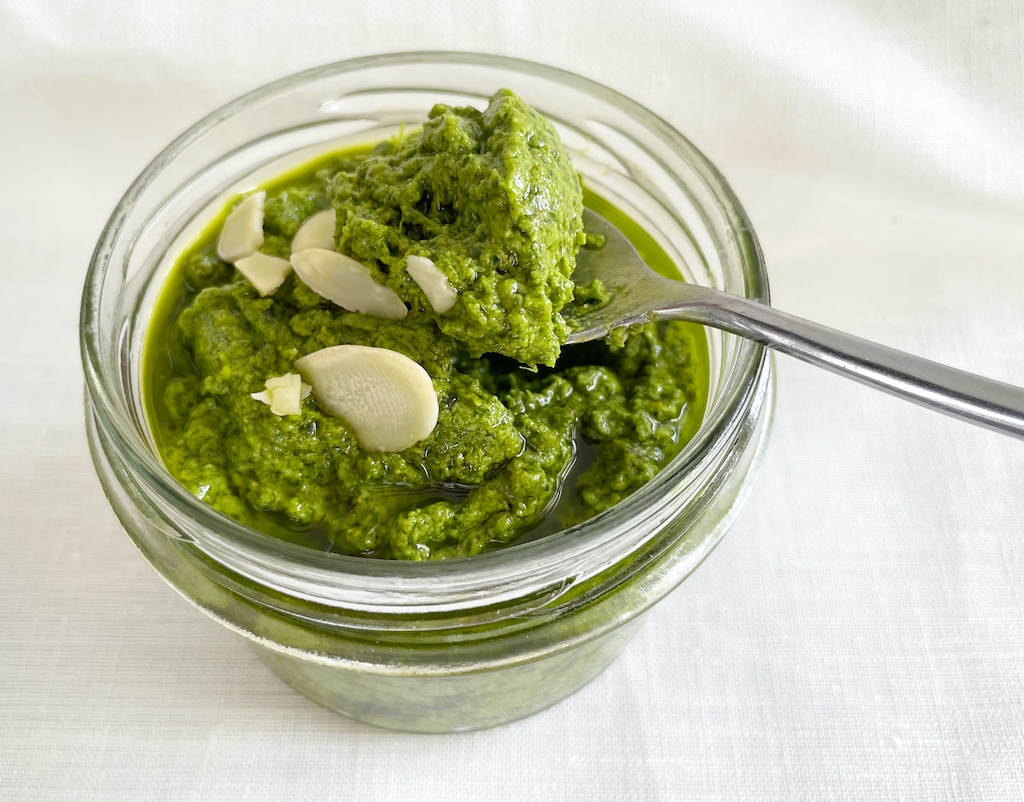 sorrel pesto in a jar with a little bit on the spoon seen from the front