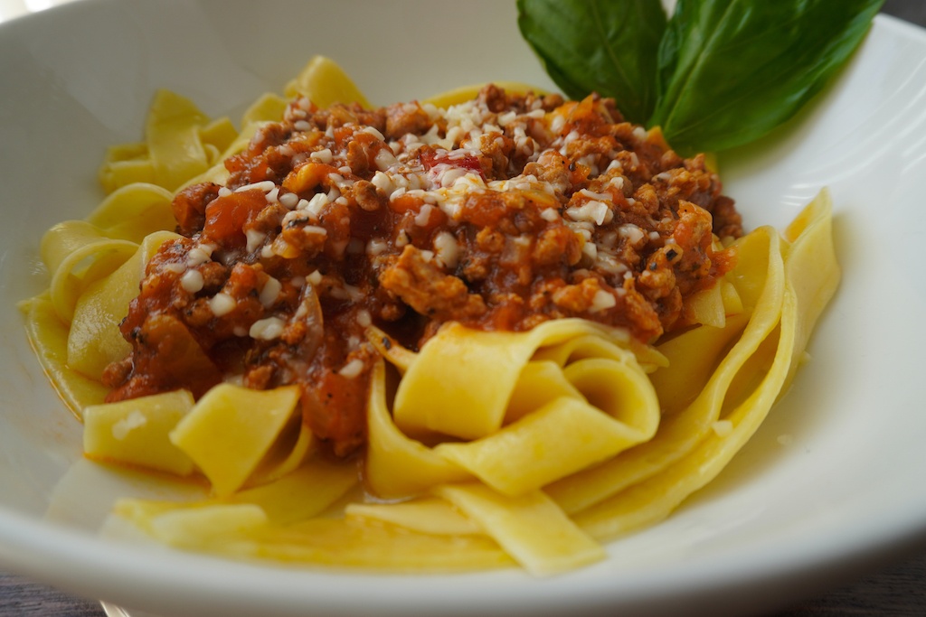 spaghetti bolognese in pasta bowl super close view on the sauce