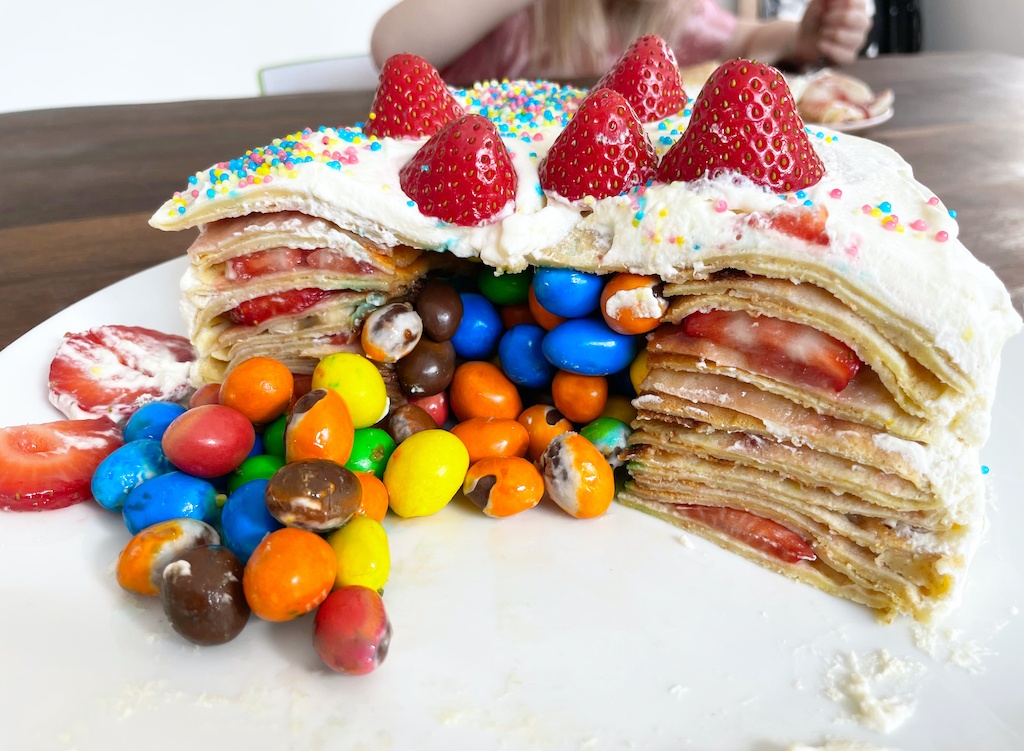 strawberry birthday cake with candy falling out of the inside