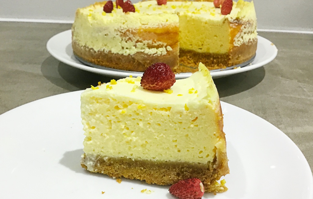 vanilla cheesecake - a piece with the whole cake in the background