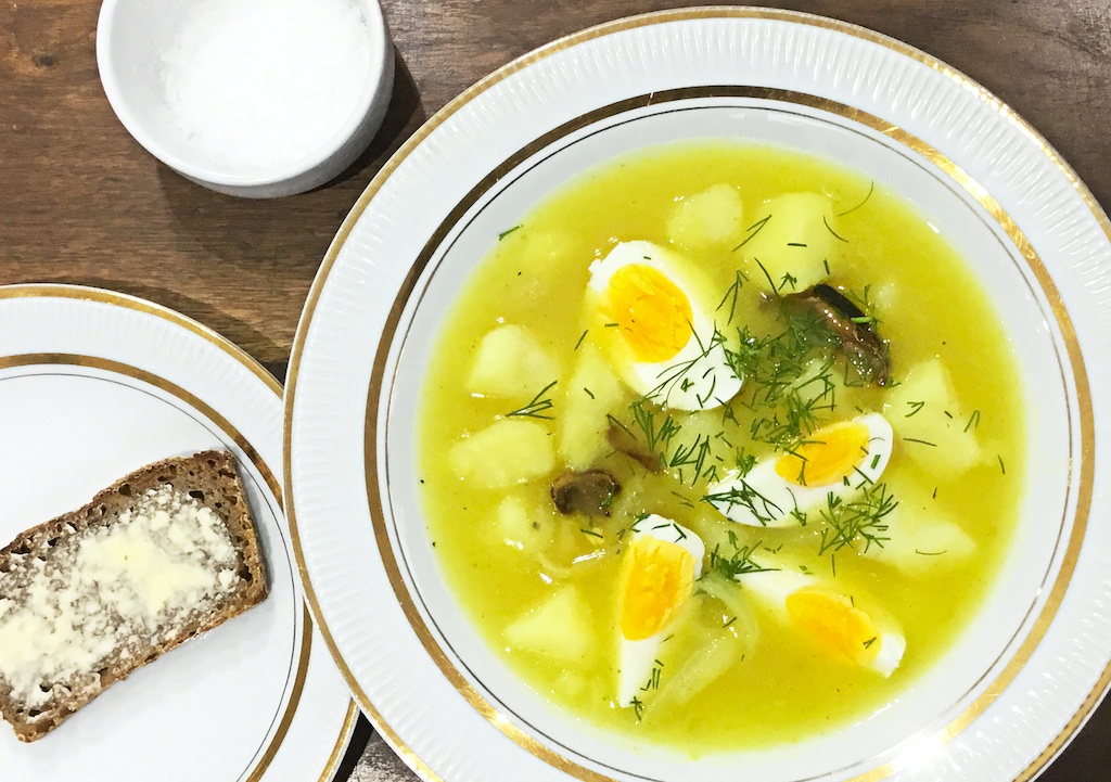 white borscht with a slice of bread and salt at the side