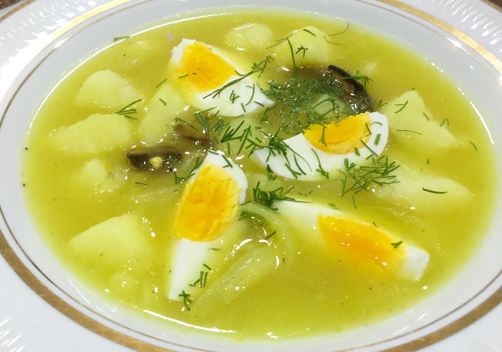 white borscht with a quartered egg on the serving plate