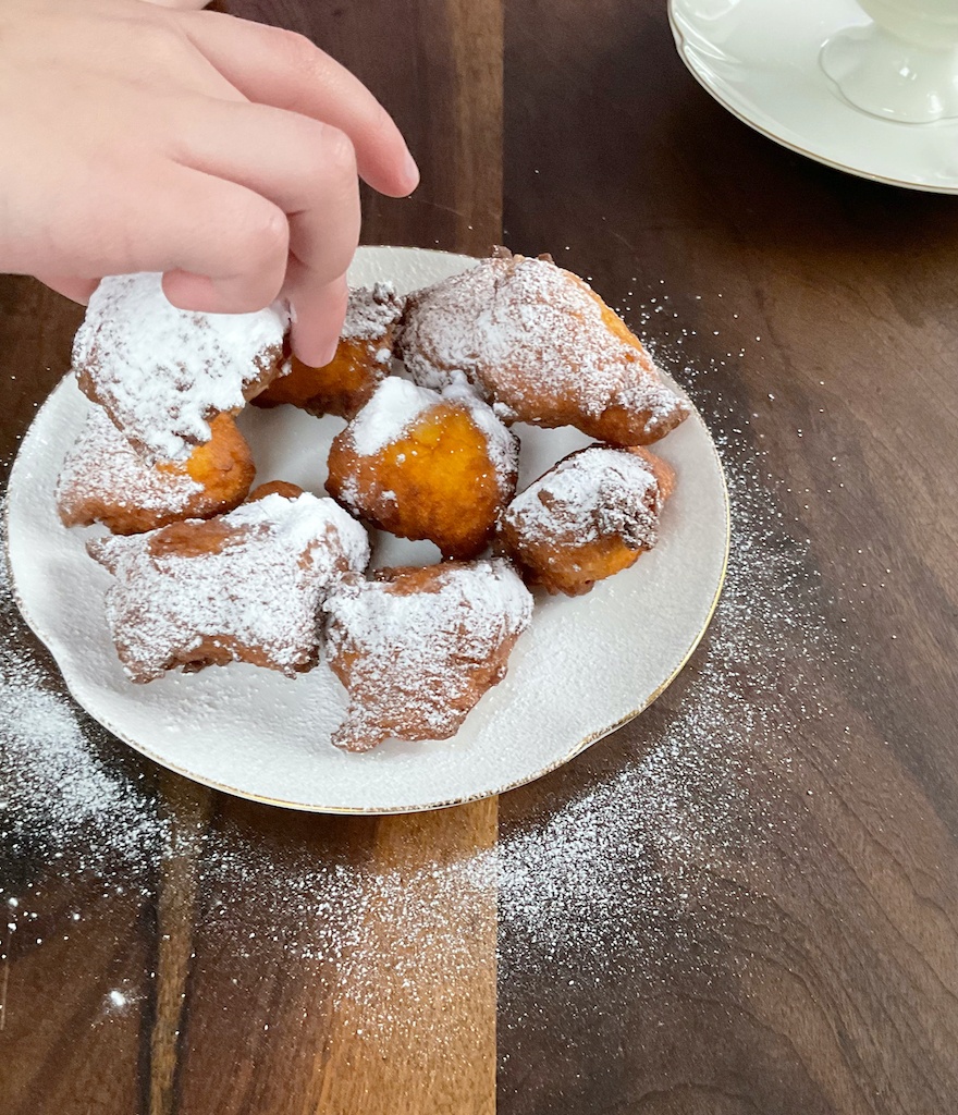 yoghurt doughnuts on the plate with child's hand snatching one